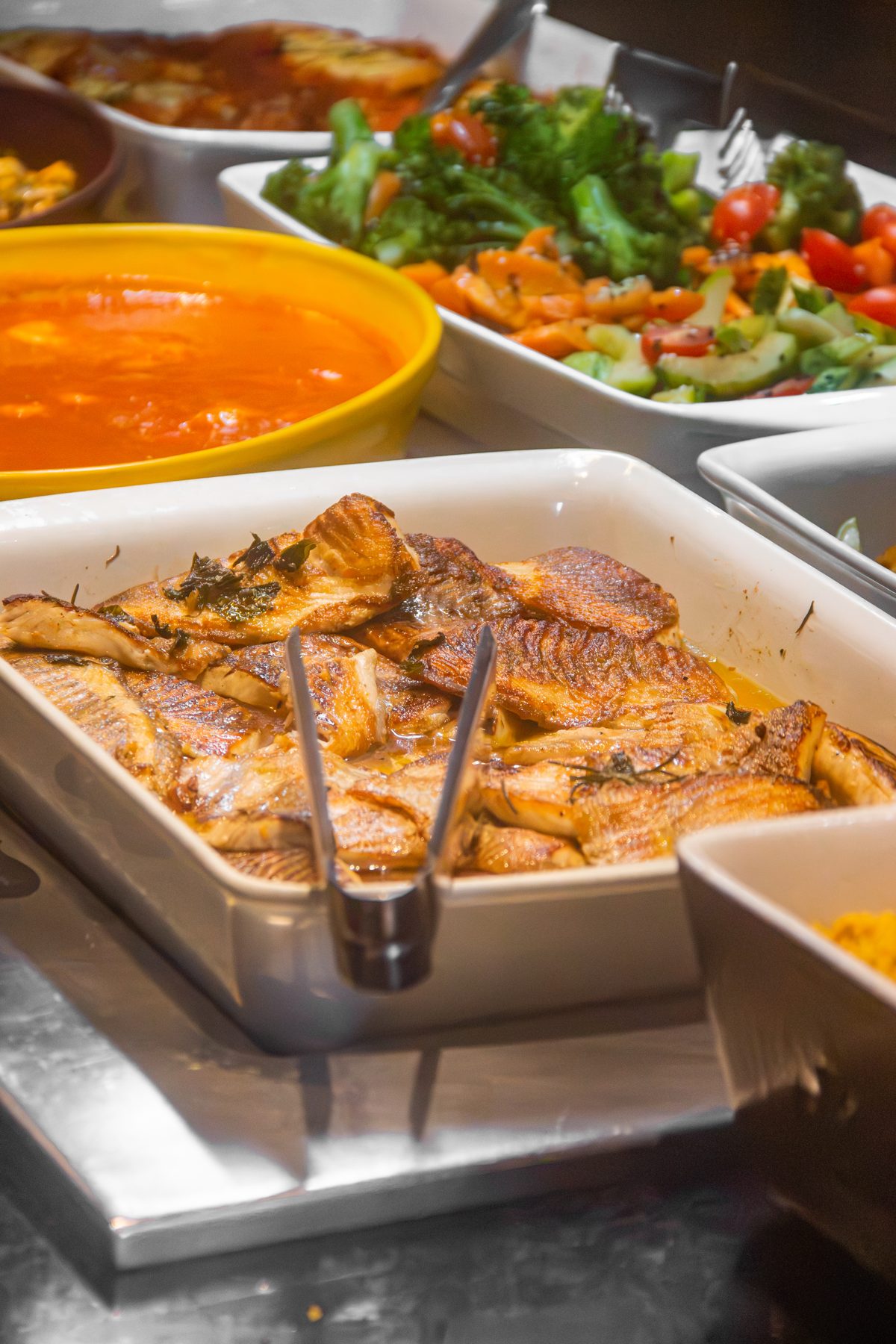 Peixe assado e legumes no buffet